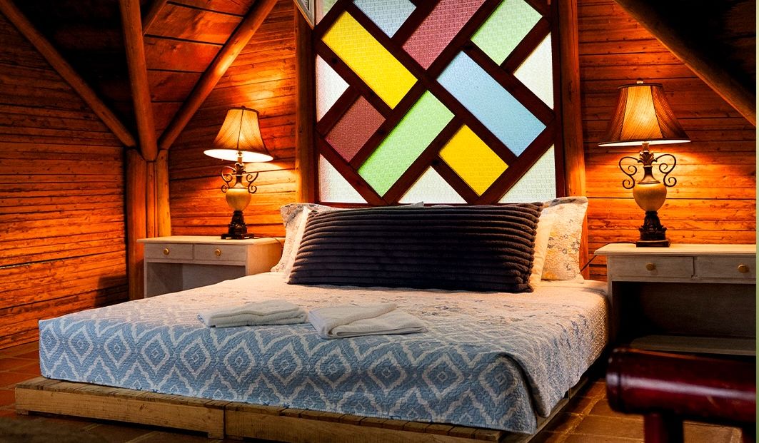 Wooden room with a colorful stained-glass window and warm lamps